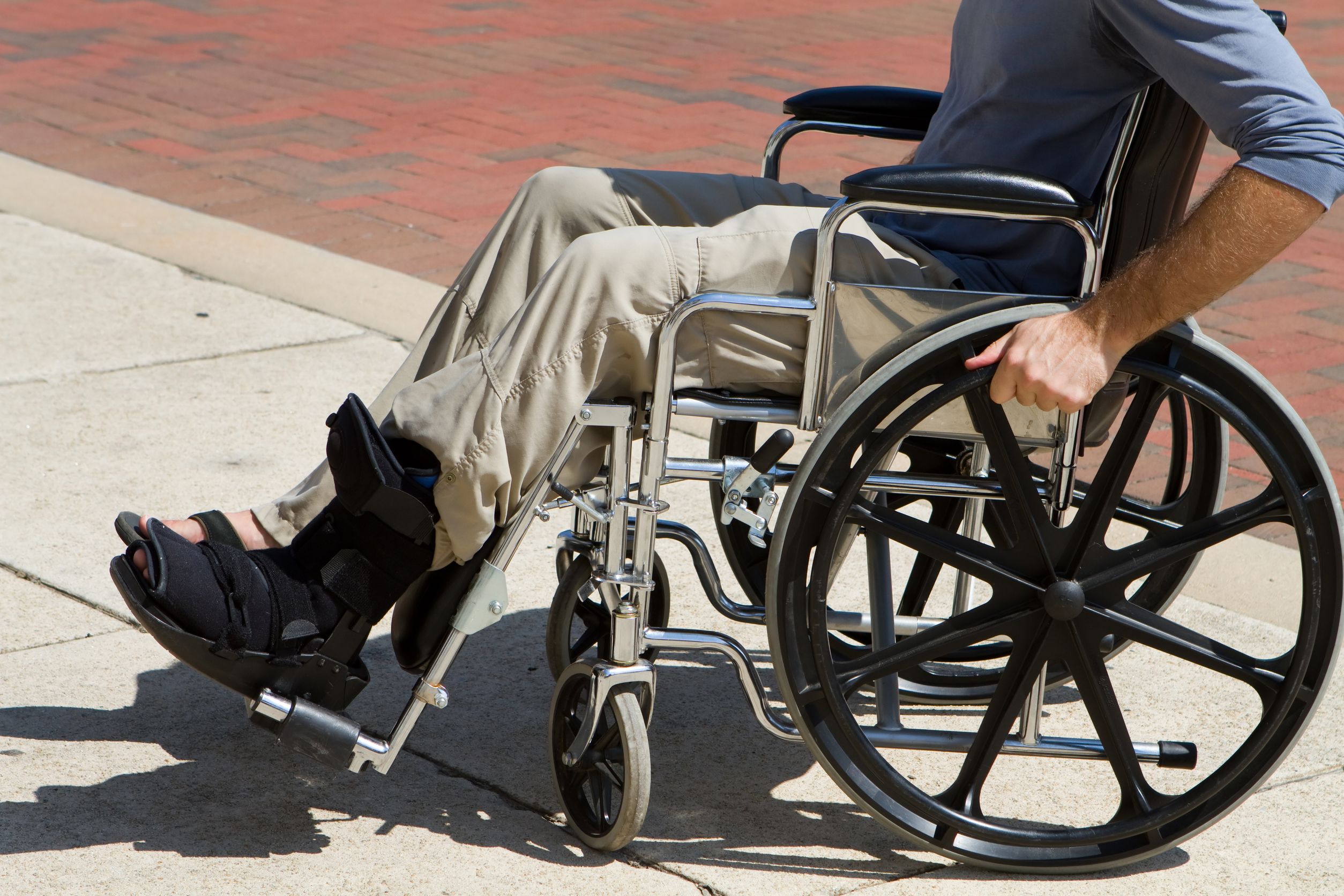 15737390_l-Injured-man-with-a-broken-foot-pushes-himself-along-in-his-wheelchair