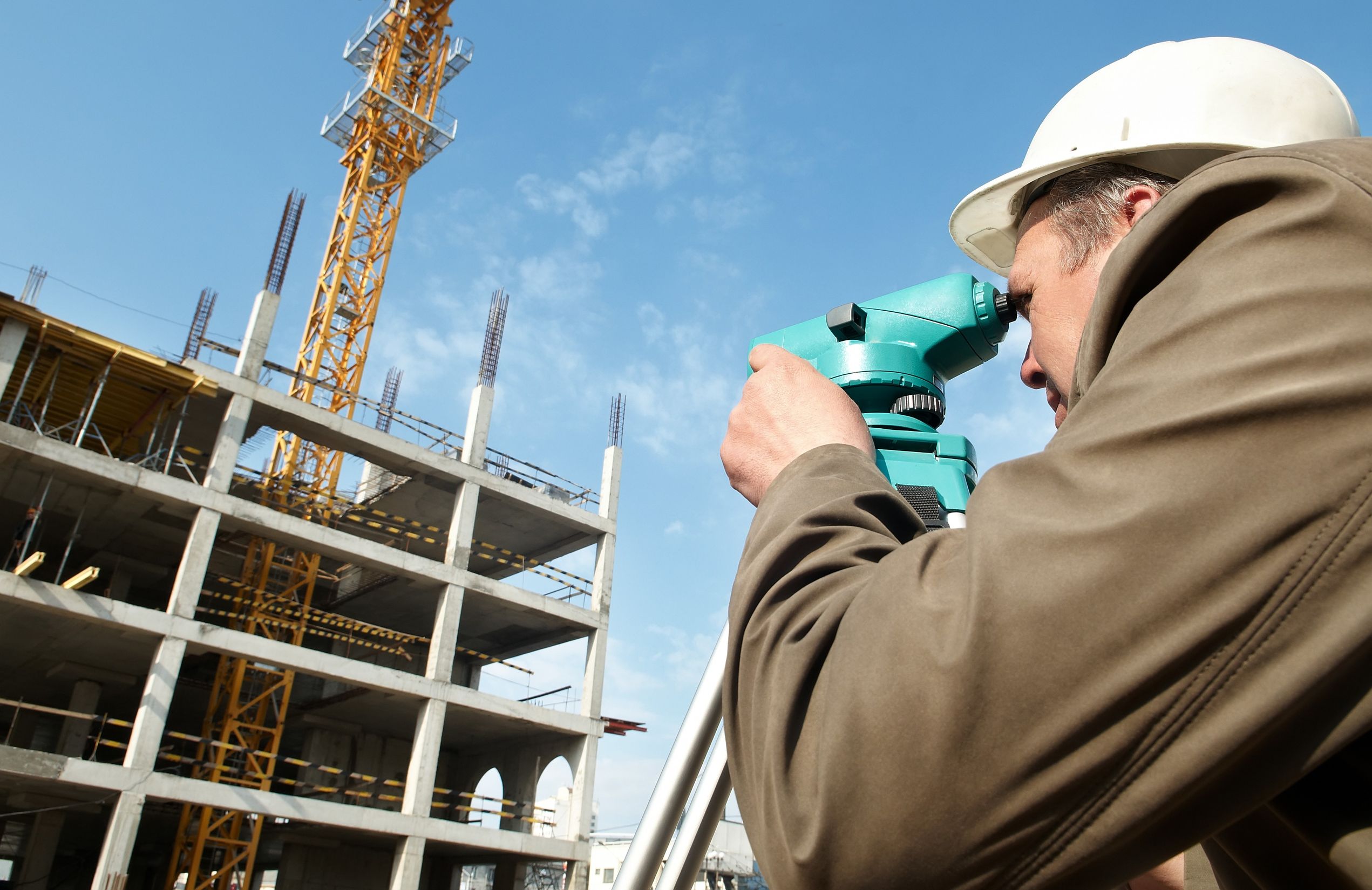7421530_l-worker surveyor measuring distances, elevations and directions on construction site by theodolite level transit equipment